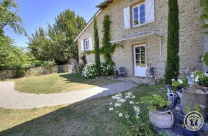 A stone house with a gravel driveway, a bicycle, and potted plants. - La Grande Maison sur la Colline - Boistrolles (VAL D'OINGT)