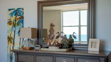A dresser with a mirror, decorative items, and a painting.