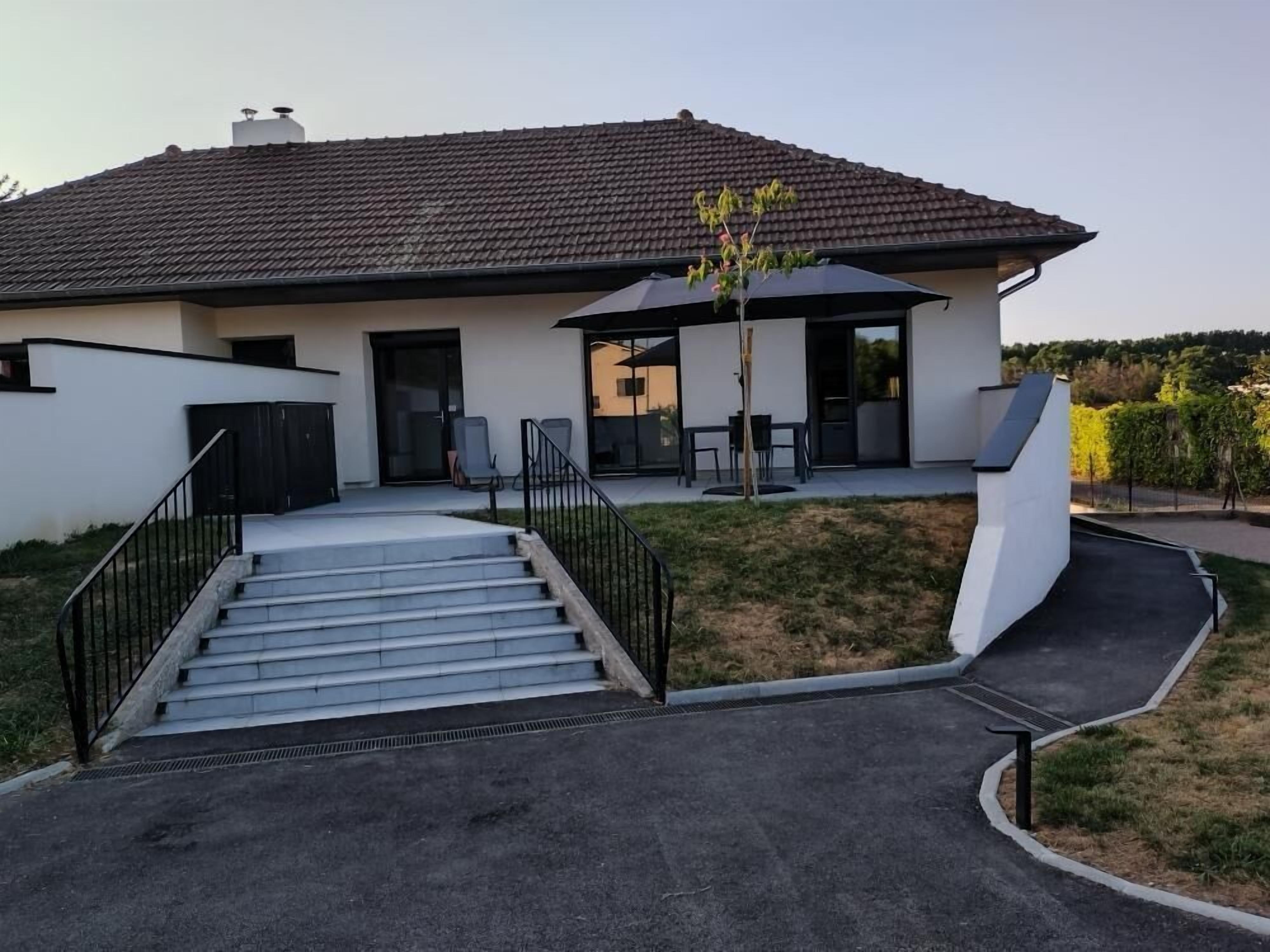 Een modern huis met een plat dak, een overdekte patio en een trap naar de ingang.