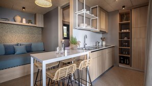 Una cocina moderna con una isla blanca, taburetes de bar y armarios de madera.