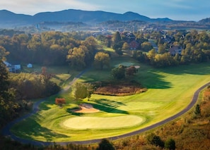 Un parcours de golf doté d’un green d’entraînement, de bunkers de sable et d’un fairway.