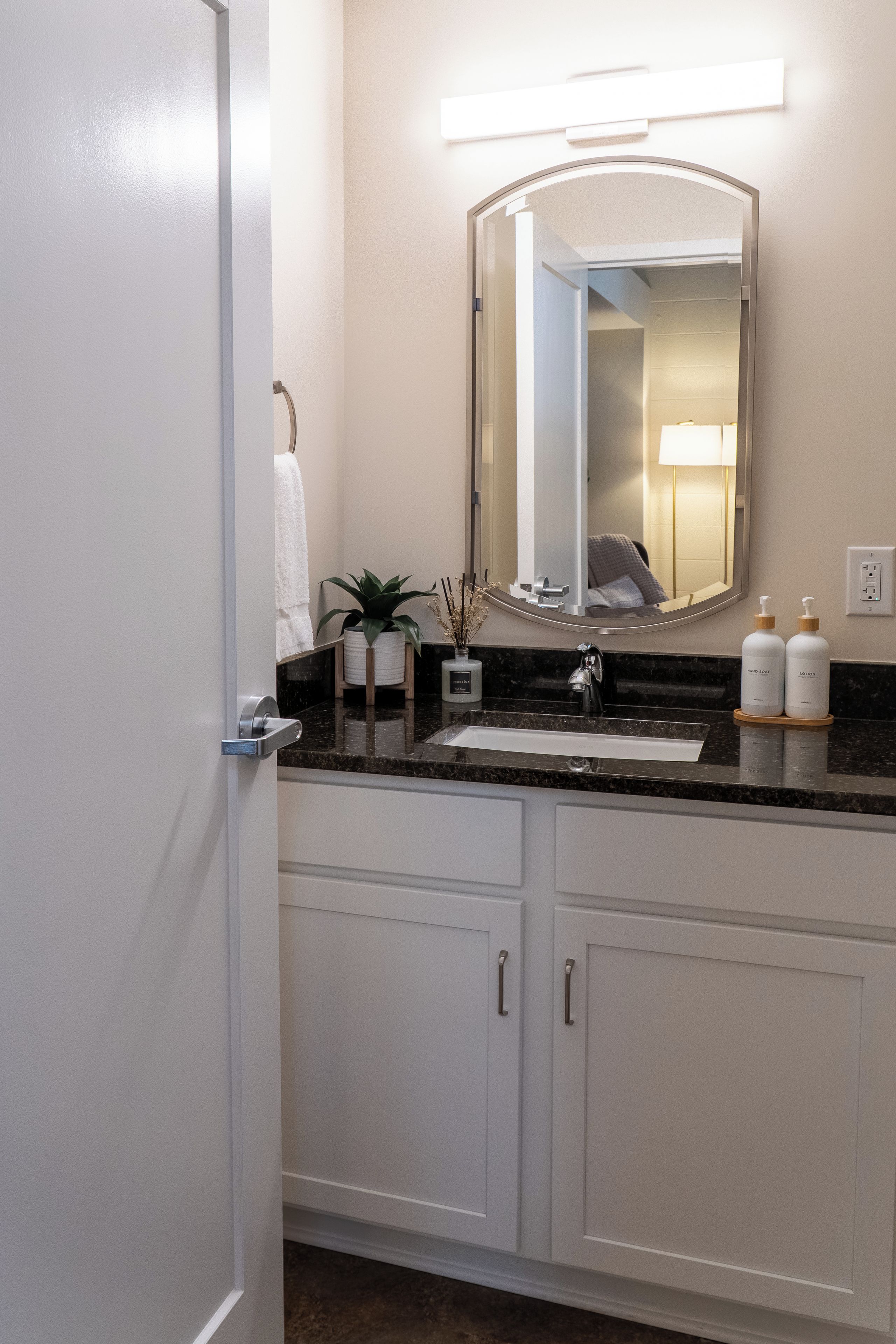 Bathroom vanity with vanity storage and arched mirror