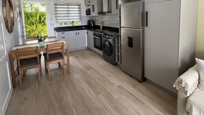 Een moderne keuken met grijze kastjes, een inbouwoven en een wasmachine.