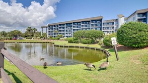 A pond with ducks, a 'No Fishing' sign, and a building with balconies in the background. - Oceanfront Studio with resort amenities (Myrtle Beach)