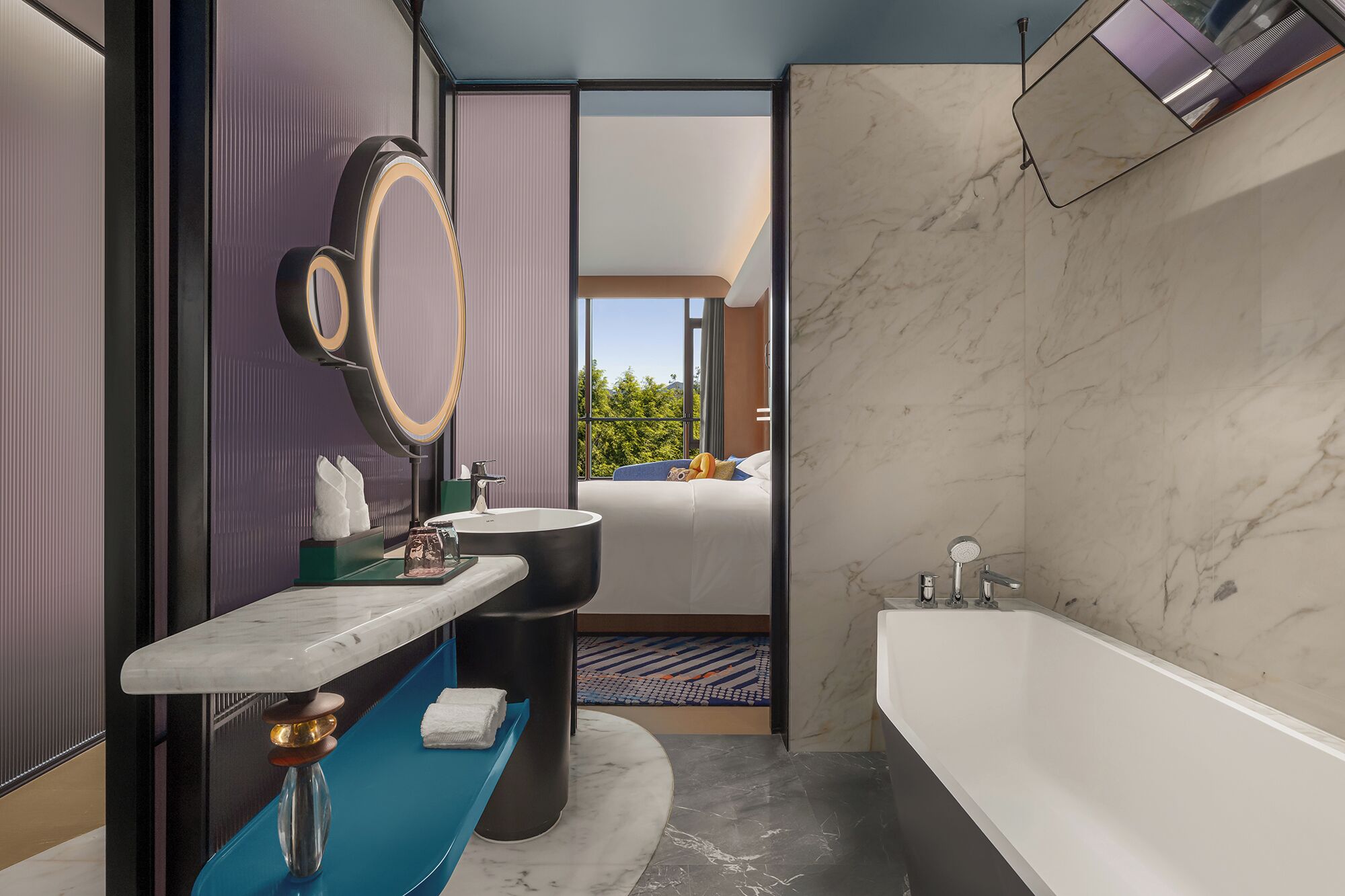 Un bagno moderno con una vasca da bagno ampia, un mobile vanitario con piano in marmo e uno specchio grande.