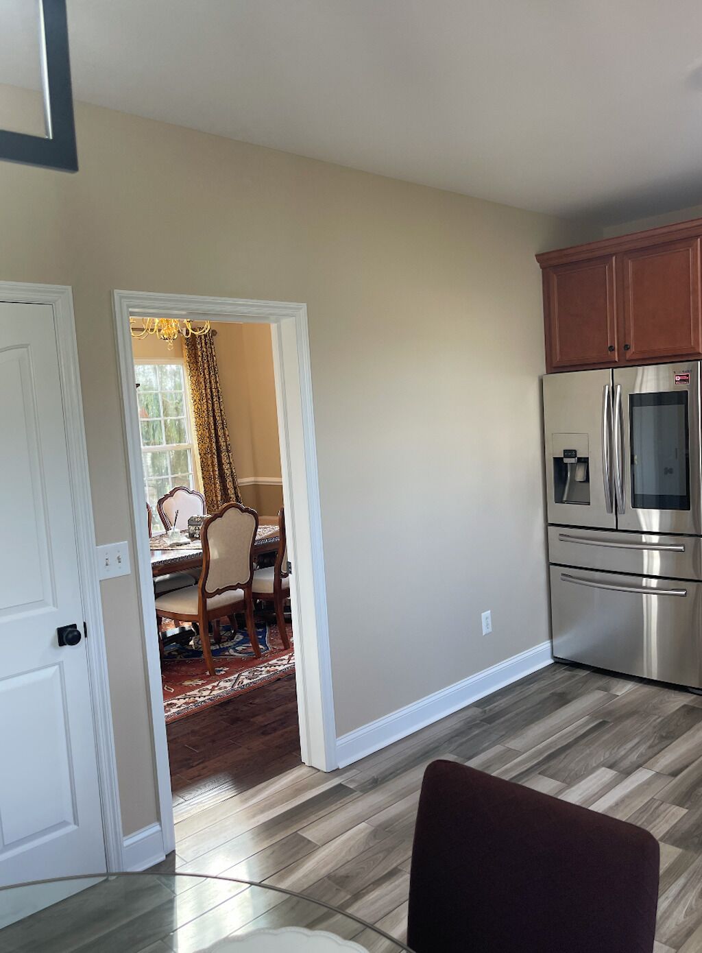 A kitchen with a stainless steel refrigerator and wooden cabinets.