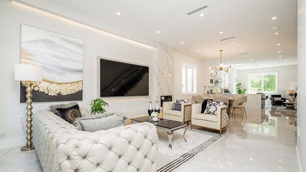 A spacious living room with a large sofa, a coffee table, and a dining area with chairs. - 3 bed 3.5 bath modern luxurious home. Minutes to downtown, Airport and Granville (Vancouver)