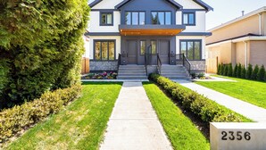 A modern two-story house with a stone facade, a well-maintained lawn, and a clear pathway leading to the entrance. - 3 bed 3.5 bath modern luxurious home. Minutes to downtown, Airport and Granville (Vancouver)