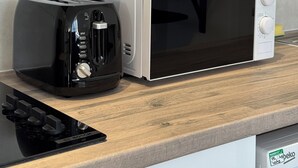 A kitchen with a toaster, a microwave, and jars on the countertop. - Coastal comforts (Portsmouth)