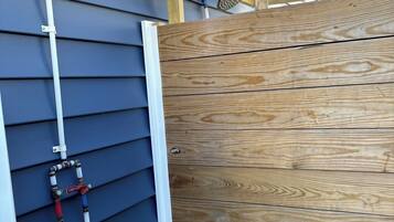 A wooden deck with a ceiling fan and a window with a grid pattern.