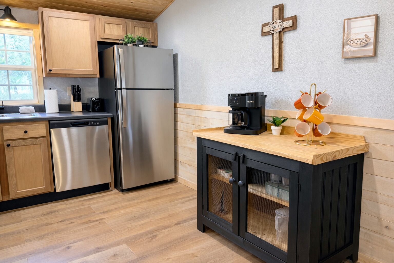 Una cucina moderna con elettrodomestici in acciaio inossidabile, mobili in legno e un angolo caffè.