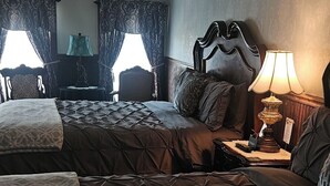 Ein Hotelzimmer mit zwei Betten, einem Nachttisch mit Lampe und einem Sessel.