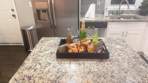 A kitchen with a granite countertop, a water dispenser, a refrigerator, and a trash can. - Serene 4-bedroom house perfect for relaxing stays in Decatur near Atl downtown (Decatur)