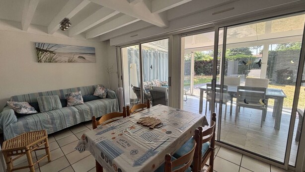 Un comedor con una mesa cubierta por un mantel, un sofá y sillas.
