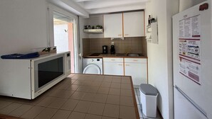 Cocina compacta con lavadora, microondas y fregadero.