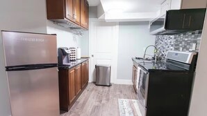 A compact kitchen with a refrigerator, microwave, and stove. - Modern Cozy Executive Suite with Private Entrance (London)