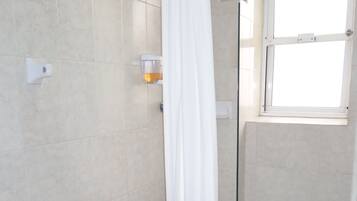 Chuveiro, toalhas de banho, sabonete, shampoo