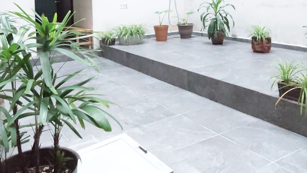 A spacious courtyard with potted plants, a balcony with string lights, and a tiled floor. - Hotel Cataviento (Veracruz)
