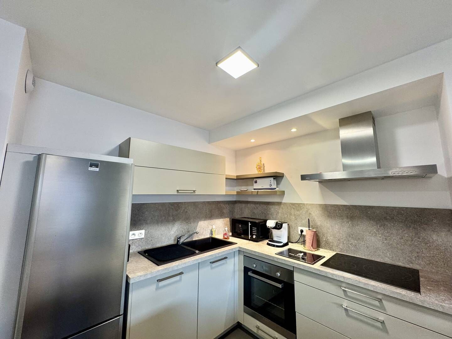 Una cocina moderna con electrodomésticos de acero inoxidable, microondas y horno empotrado.