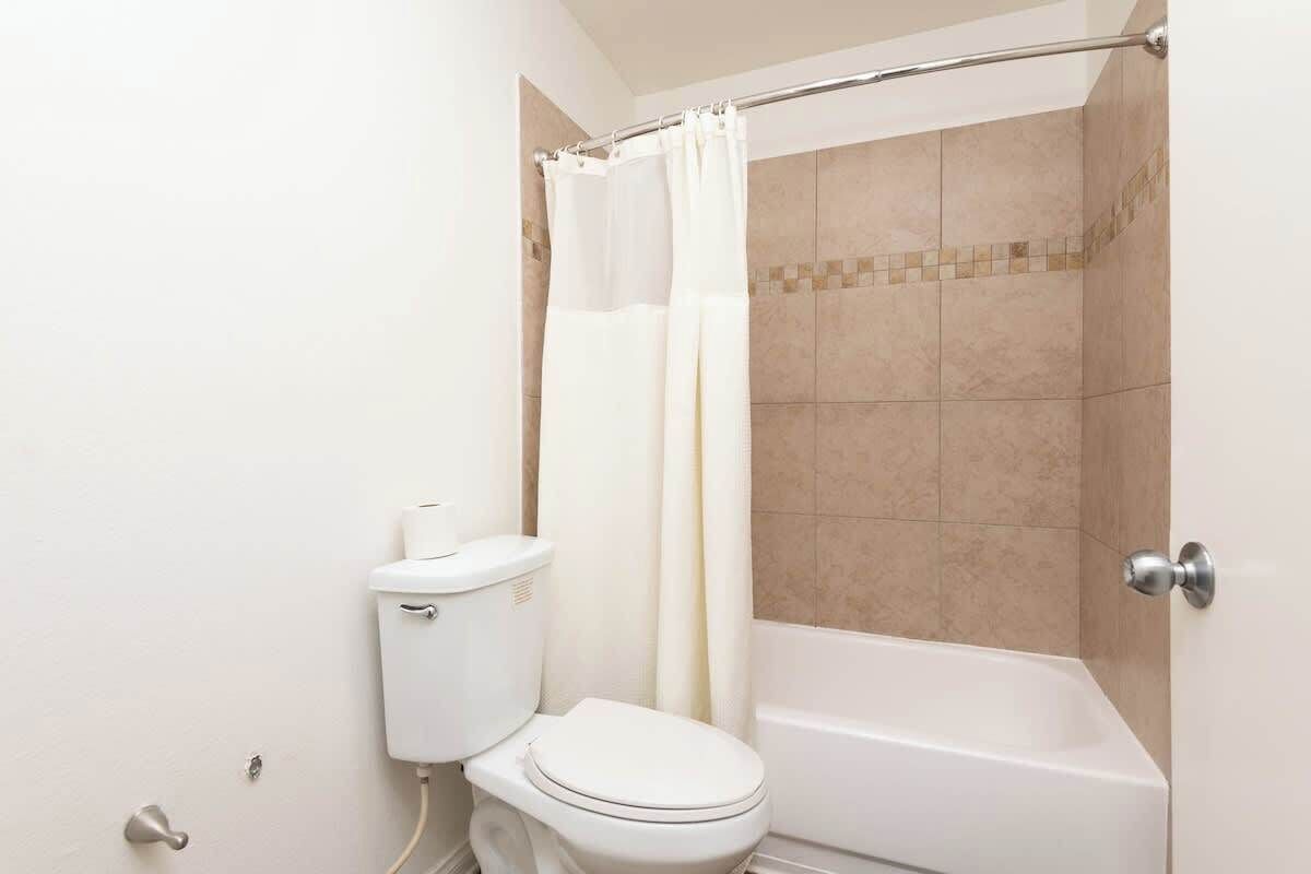 Ein Badezimmer mit Toilette, Badewanne und Duschvorhang.