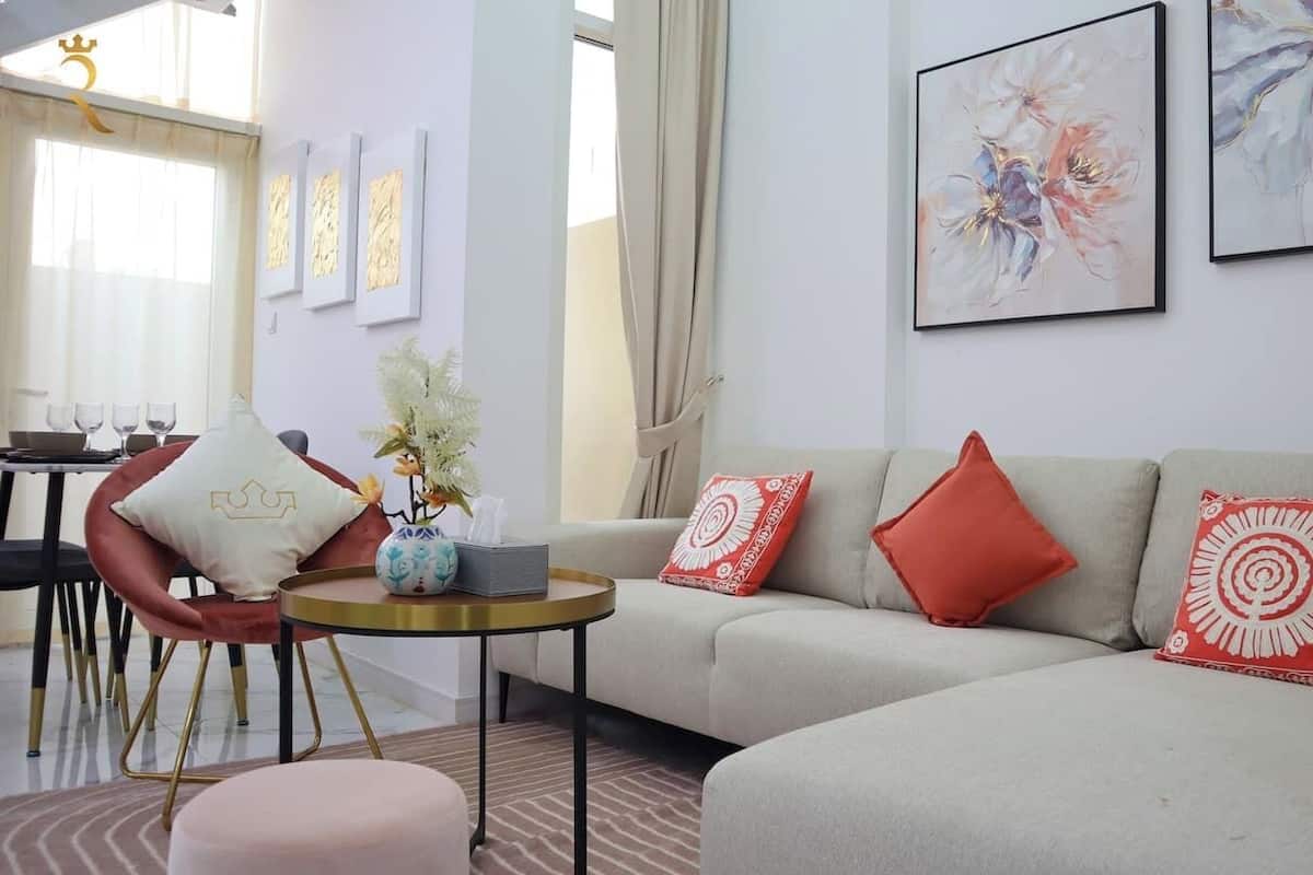 A modern living room with a sofa, chairs, a coffee table, and artwork on the walls.