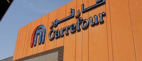 A Carrefour store sign with Arabic text and a stylized 'M' logo.