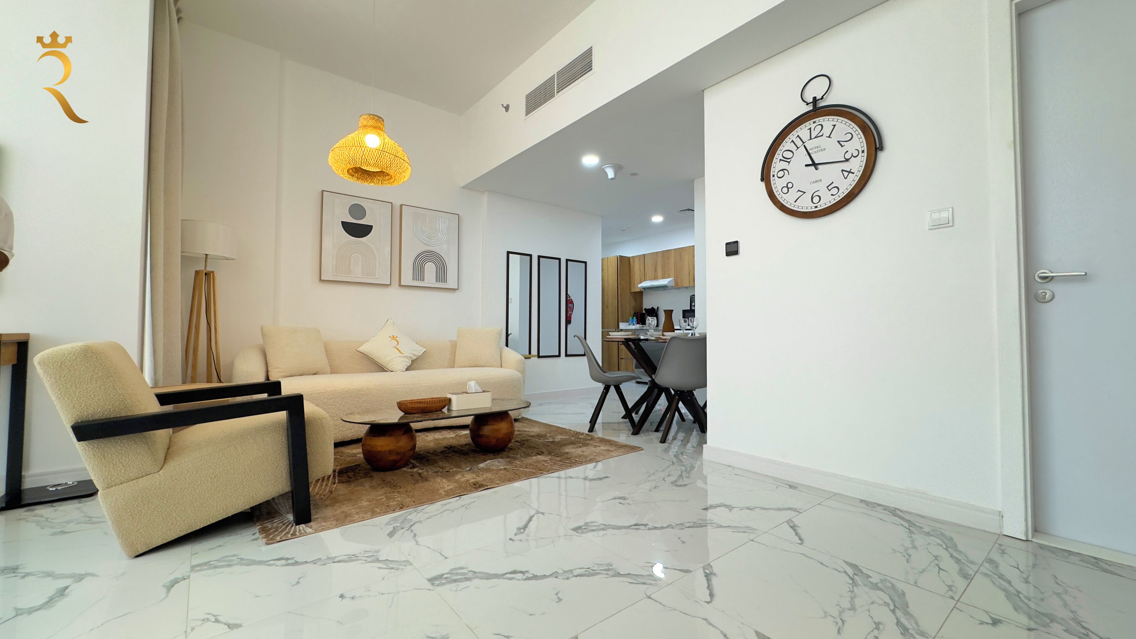 A modern living room with a sofa, coffee table, and a dining area with chairs and a table.