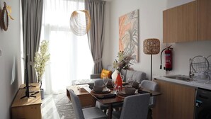 Un salon moderne comprenant un coin repas, une cuisine et une grande fenêtre avec des rideaux.