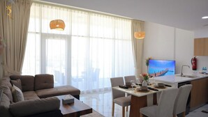 Un salon moderne comprenant un canapé, une table à manger et un coin cuisine.