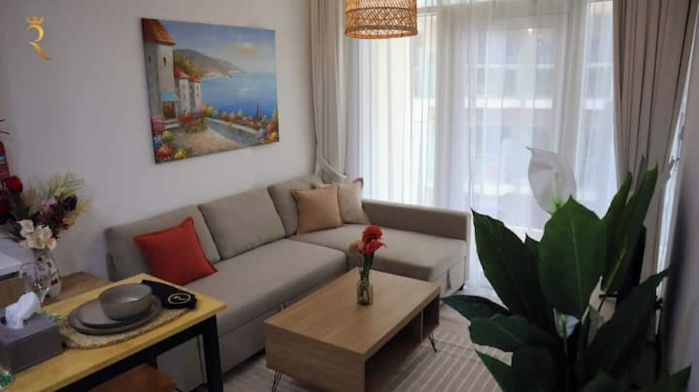 Een moderne woonkamer met een bank, salontafel en een schilderij aan de muur.