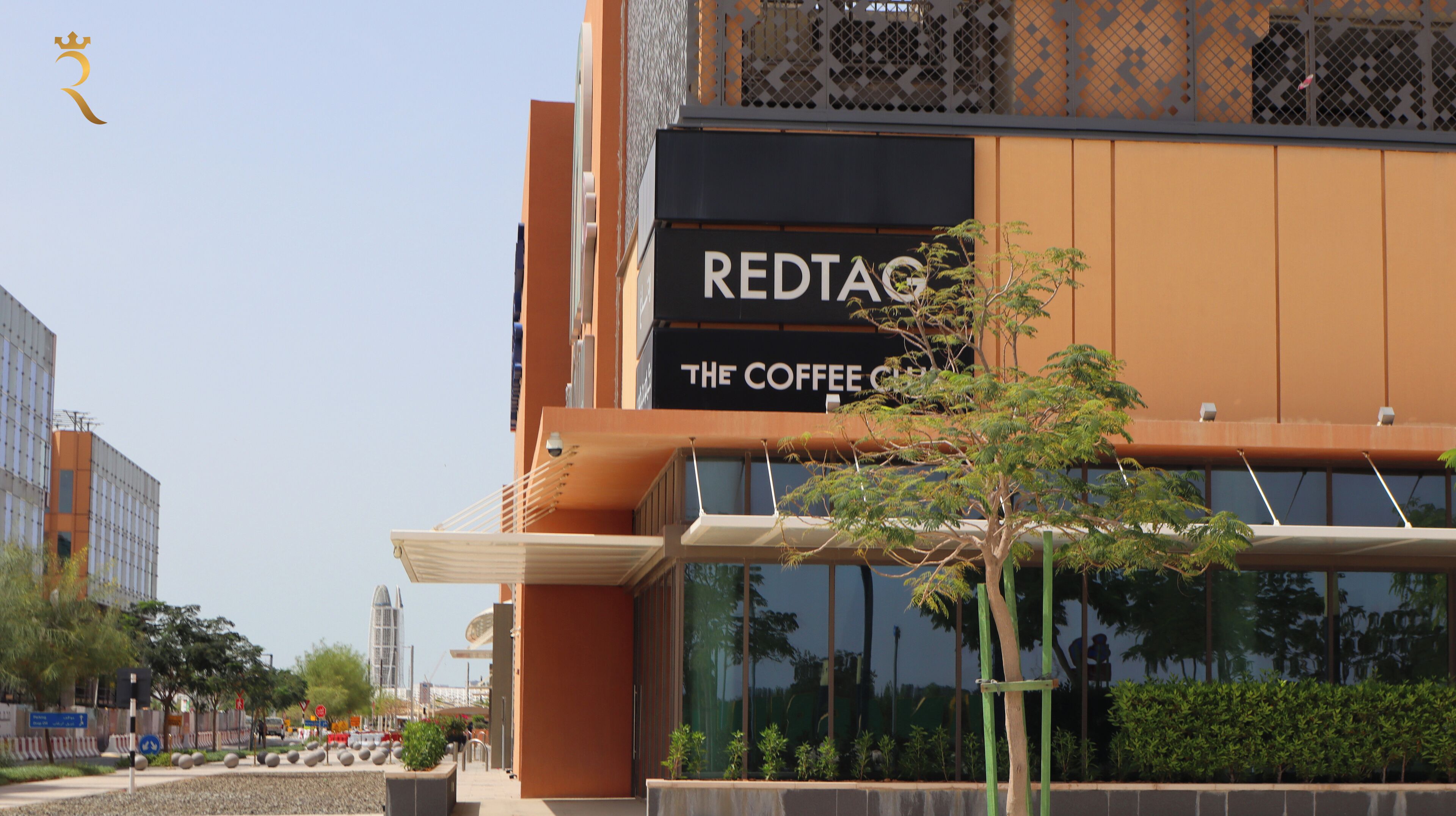 Un edificio moderno con un cartello per 'REDTAG The Coffee Company'.