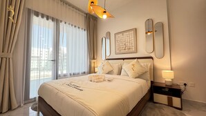 A hotel room with a large bed, a bedside table with a lamp, a window with curtains, and a framed picture on the wall. - Masdar Oasis 1 Modern Apartmenst By Rhh (Abu Dhabi)