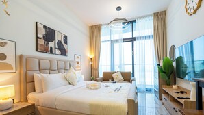 Une chambre d’hôtel moderne équipée d’un grand lit, d’une télévision, d’un bureau et d’une fenêtre avec des rideaux.