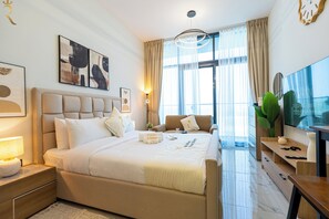 Una moderna camera d'hotel con un letto grande, una televisione, una scrivania e una finestra con tende.