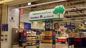 Un supermarché Carrefour avec une grande enseigne accueillant les clients, des rayons remplis de produits et des panneaux promotionnels annonçant des offres et des prix bas.