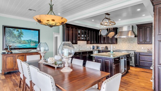 A spacious kitchen with dark wood cabinets, a large island with seating, and modern appliances.