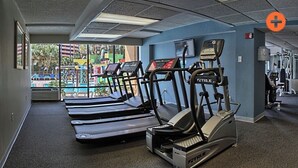 Een sportschool met loopbanden, een crosstrainer en een hometrainer.