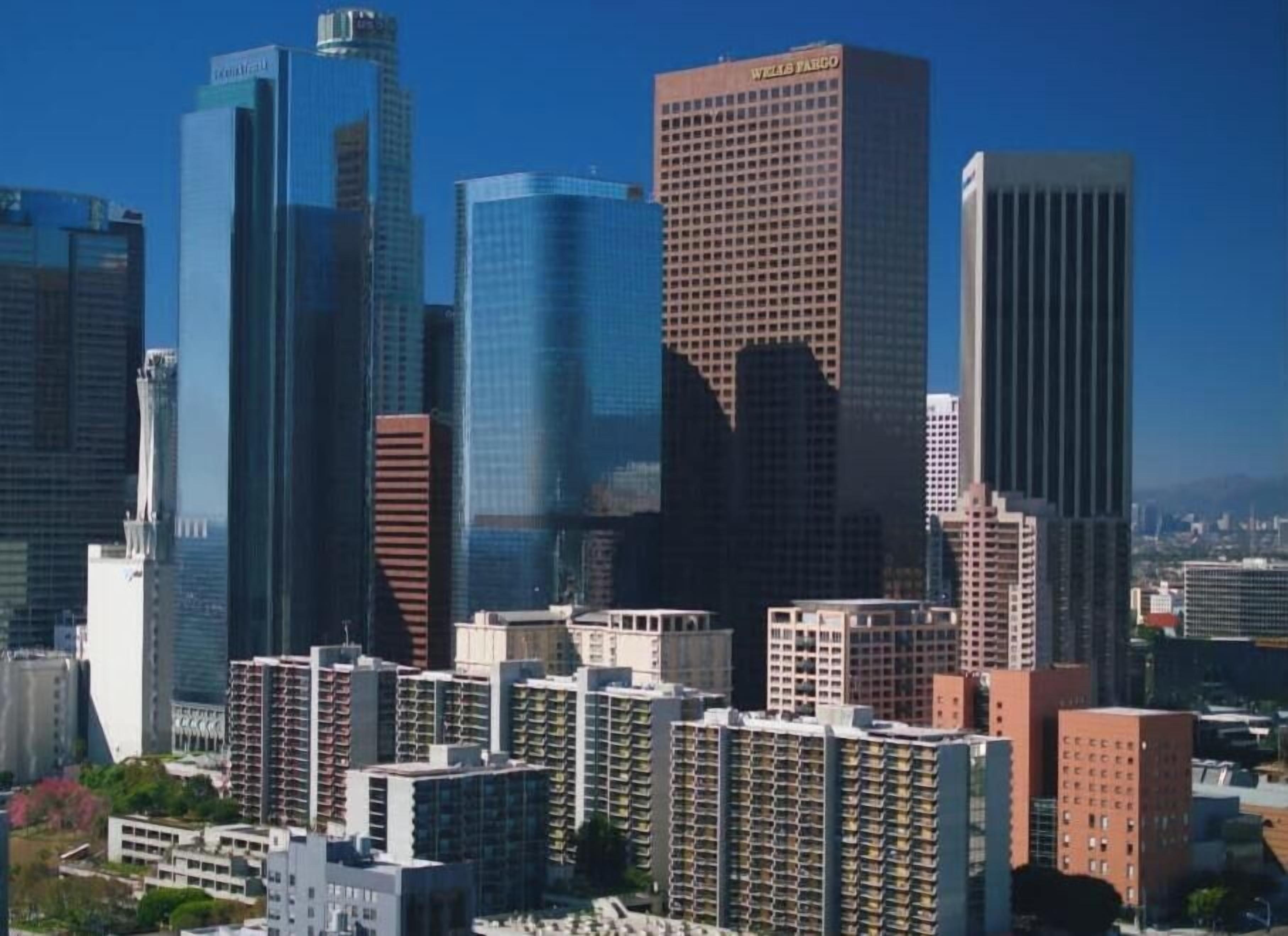 A cityscape with modern high-rise buildings, including a prominent Wells Fargo building.
