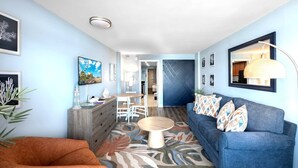 A modern living room with a sofa, coffee table, and a TV on the wall. - Landmark 633 (Myrtle Beach)