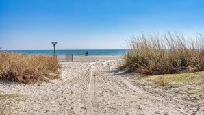 A sandy beach path leading to the sea with a warning sign and a person in the distance. - Landmark 633 (Myrtle Beach)