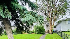 Camí cap a una casa amb un jardí petit i una tanca metàl·lica.