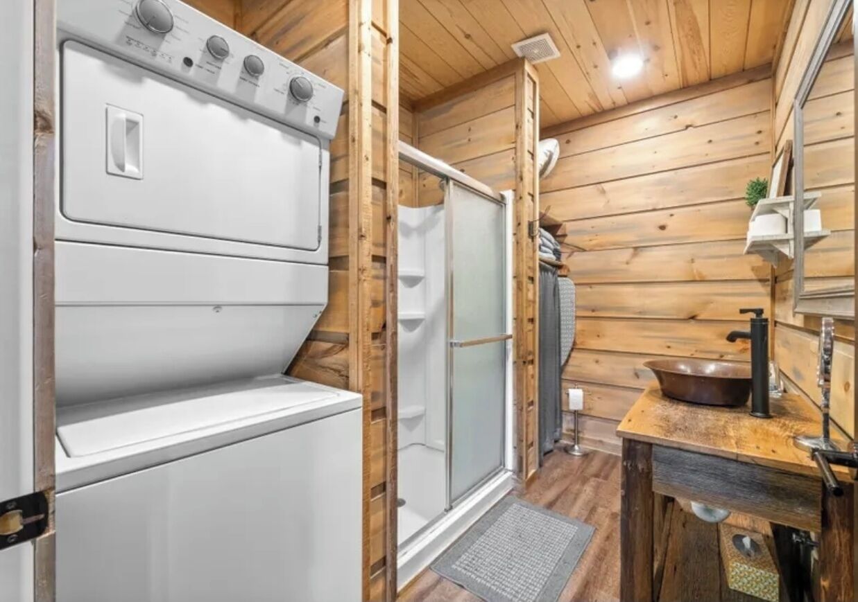 Eine kleine Küche mit Einbauofen, Spüle und einer Holz Arbeitsplatte.