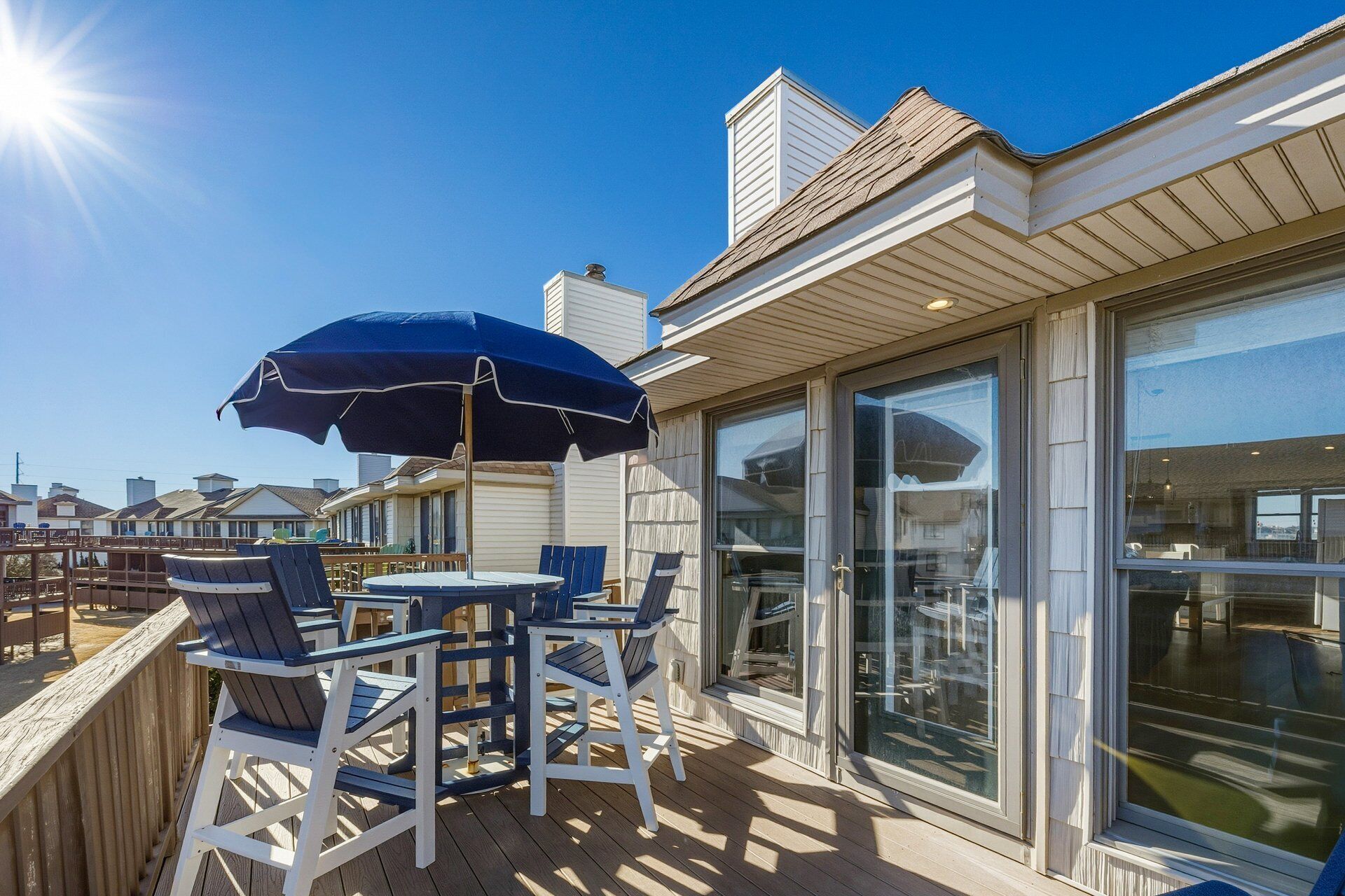 A deck with outdoor seating and a large umbrella.