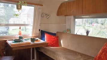 Un interior acogedor con un sofá, una mesa con platos y una planta colgante.