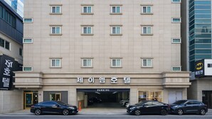 A multi-story hotel with a parking entrance. - JM HOTEL (Suwon)