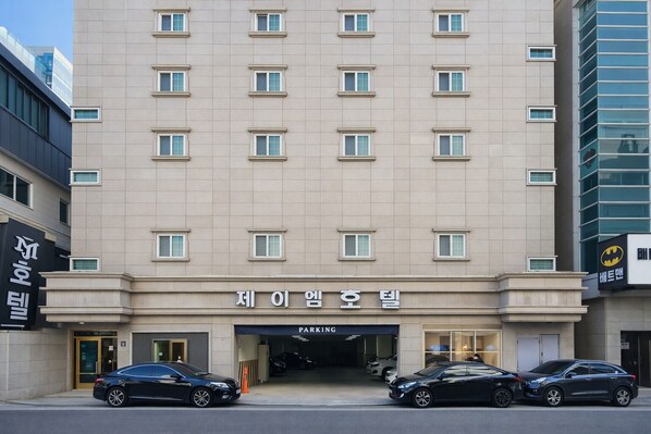 A multi-story hotel with a parking entrance. - JM HOTEL (Suwon)
