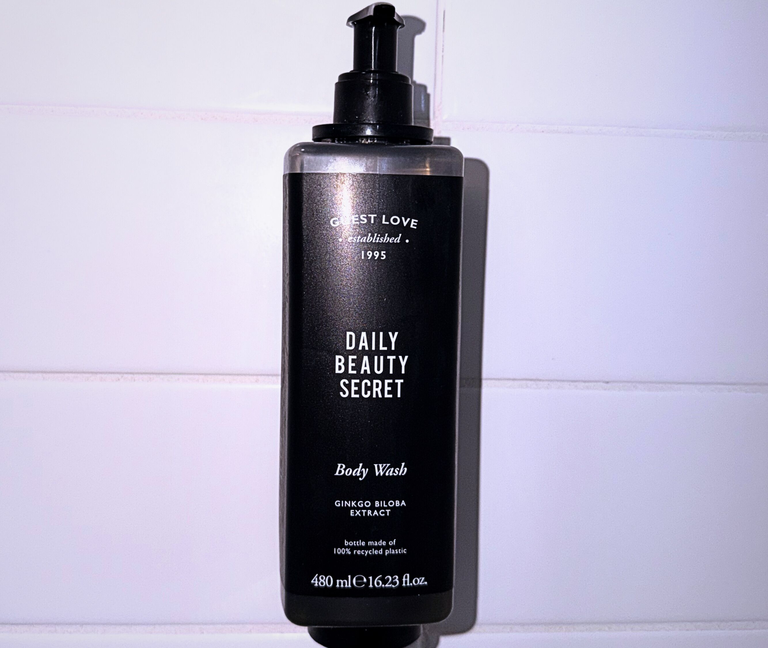 Una botella negra con el rótulo 'DAILY BEAUTY SECRET' y un dispensador tipo bomba, que indica que es un jabón corporal.