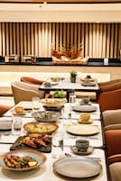 Un espace repas avec une table mise pour le repas, des chaises et, au fond, un coin cuisine.