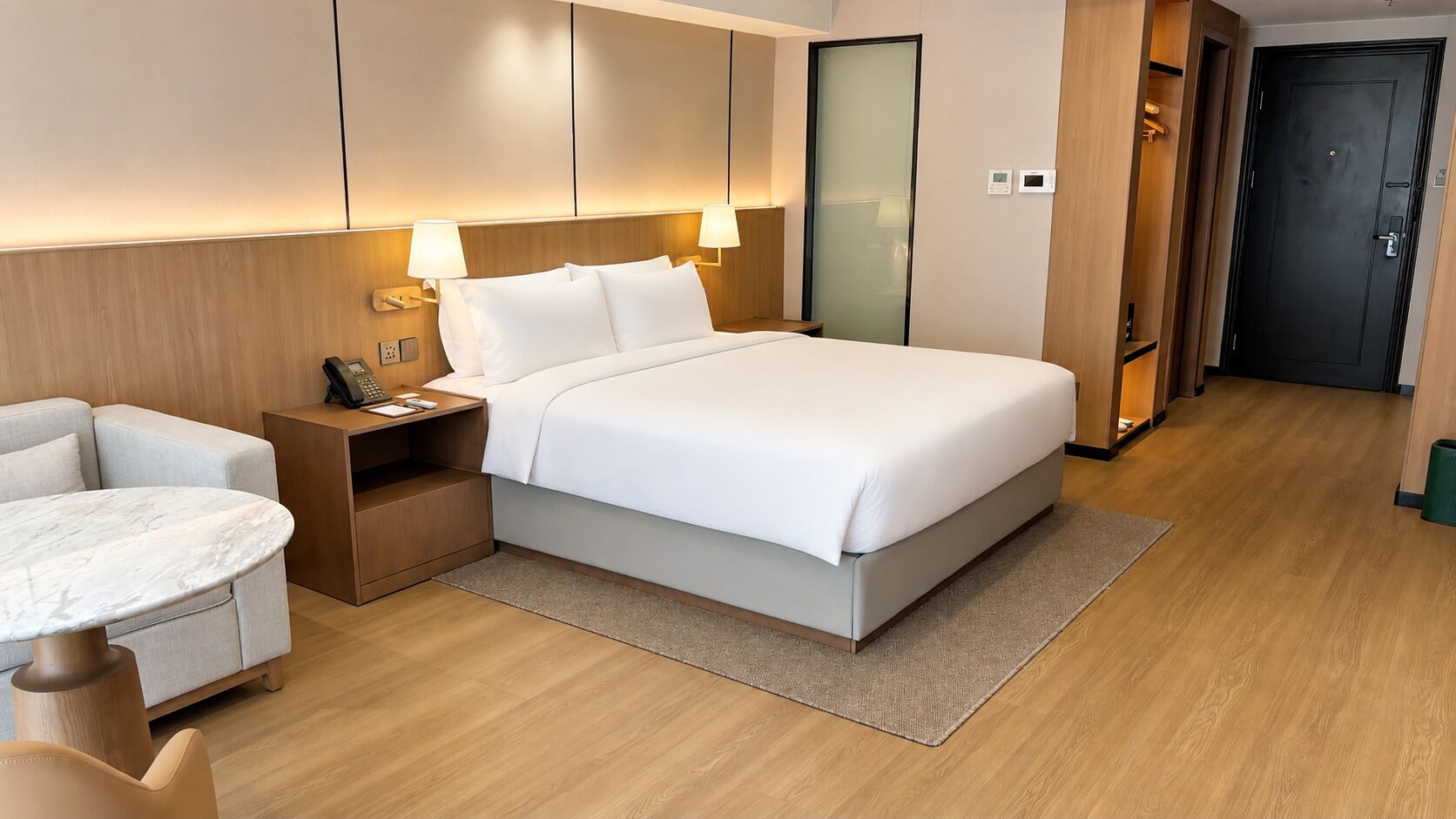 Une chambre d’hôtel comprenant un lit, des tables de chevet, un bureau et une chaise.