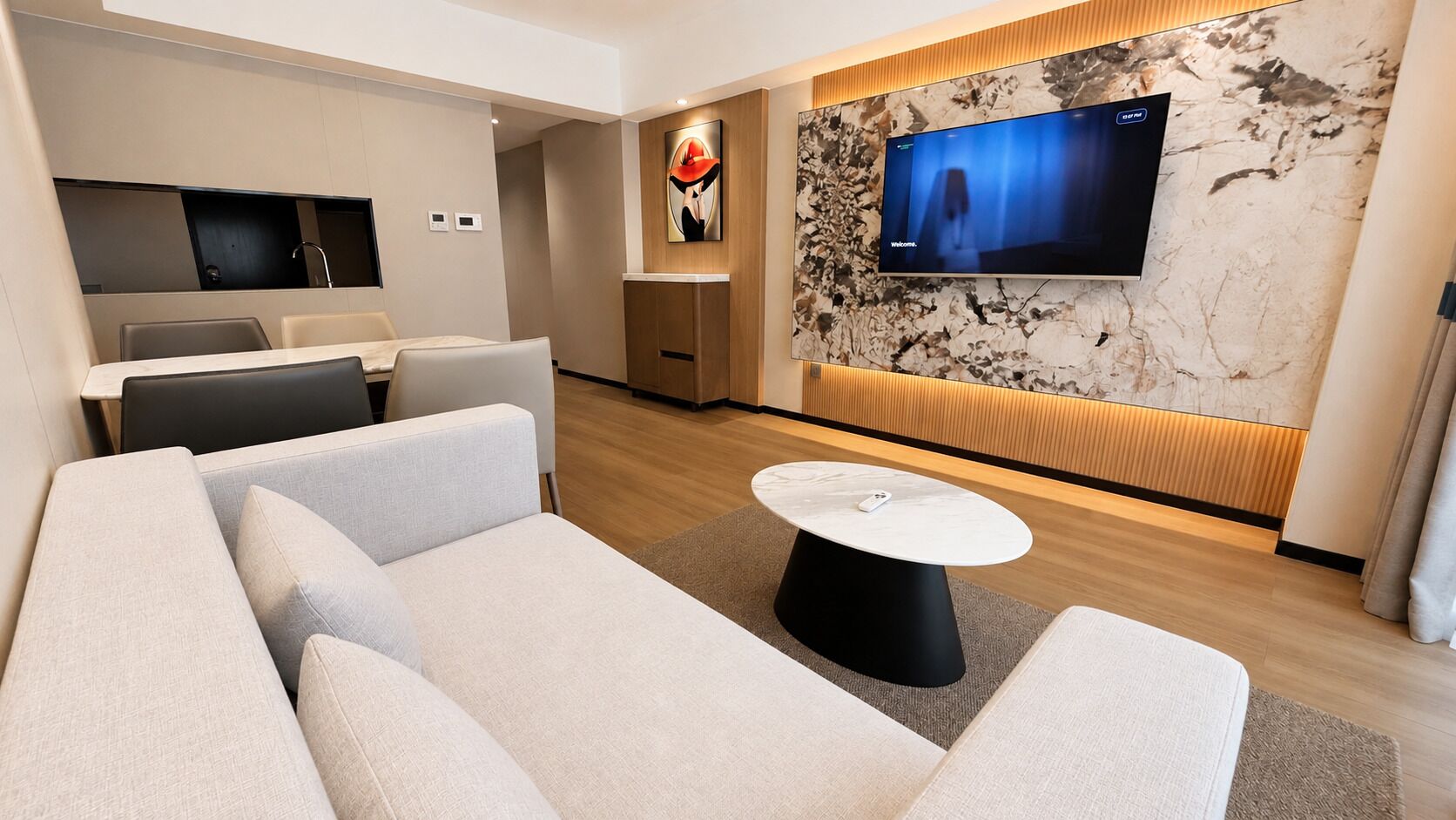 Una sala de estar moderna con un sofá, una mesita de centro y un televisor de pantalla plana montado en una pared de mármol.